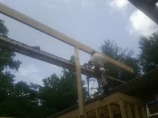 Carpenter setting a ridge beam over a new addition frame — Ice Dam Removal by Roofing Brothers in North Brookfield
