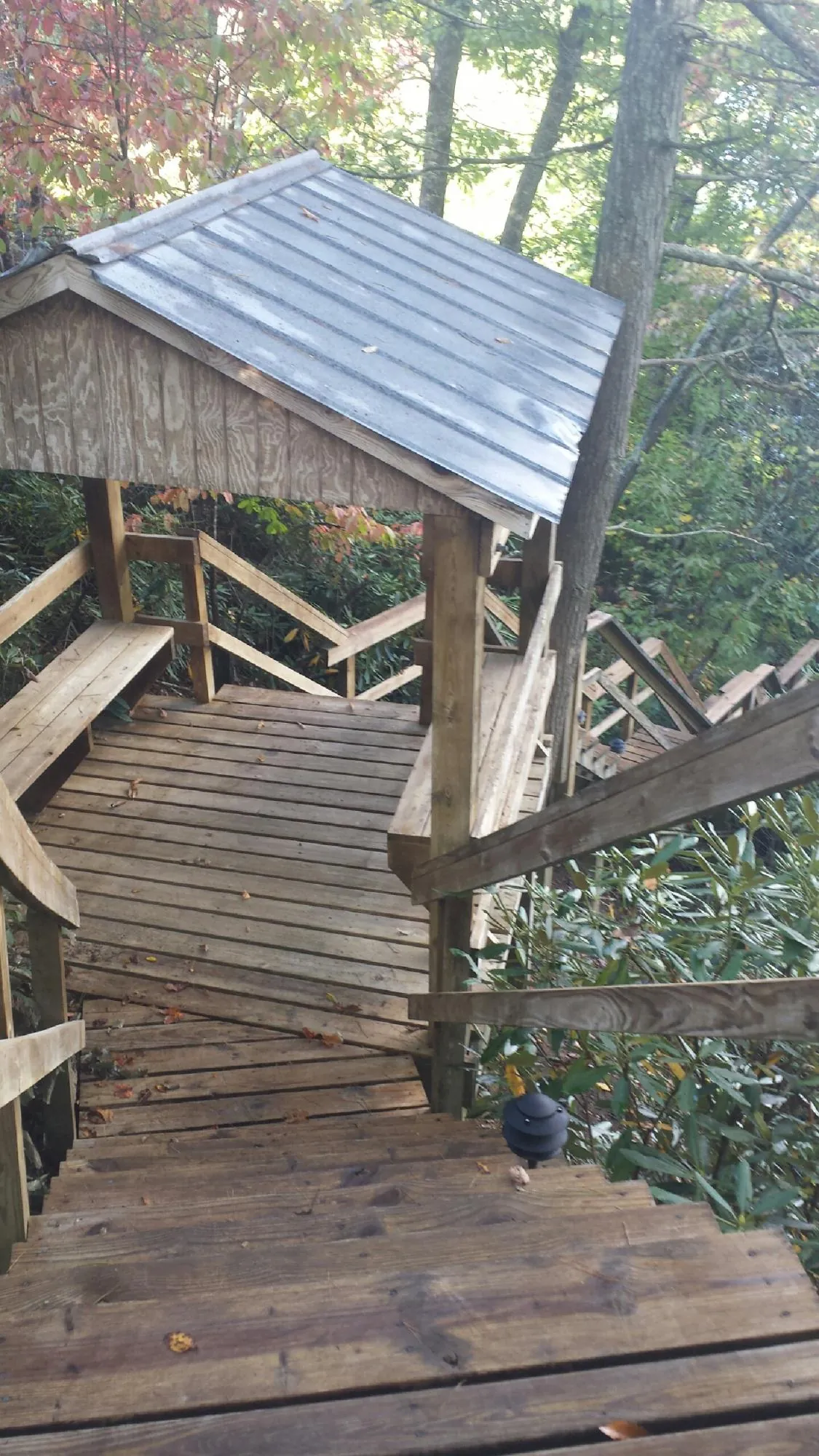 Metal roofed shelter over wooden steps on a wooded walkway — Skylight Repair & Installation work by our crew in North Brookfield
